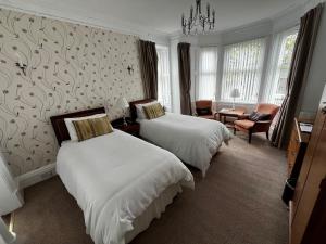 a hotel room with two beds and a chandelier at Lomond Guest House in Leven