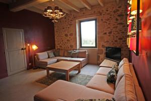 a living room with a couch and a table at Le presbytère de thiat in Thiat