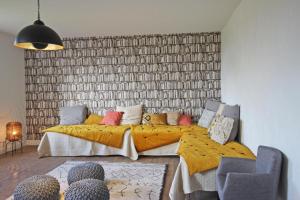 a bedroom with a large bed with a yellow blanket at Le presbytère de thiat in Thiat