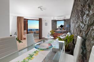 a dining room and living room with a glass table at Villa Marianna in Massa Lubrense