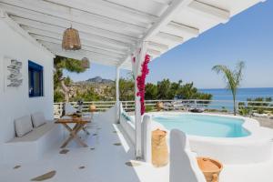 a white house with a swimming pool and the ocean at Endless Horizon At Stegna in Archangelos