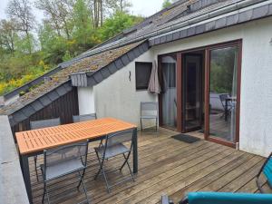 a wooden deck with a table and chairs on it at Appartement confortable Dog friendly in Membre