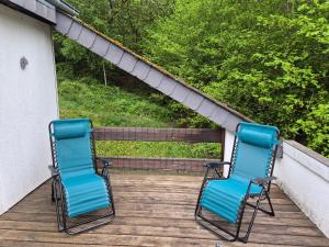 two blue chairs sitting on a porch at Appartement confortable Dog friendly in Membre