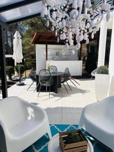 a patio with white chairs and a chandelier at Dora Design House in Człuchów +24 photos