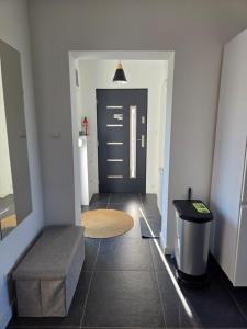 a hallway with a black door and a trash can at Apartamenty Nowielice in Nowielice +23 photos