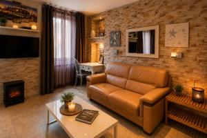 a living room with a couch and a fireplace at Appart' Spa et Sauna Privatif Au Cœur De Beaune in Beaune