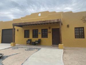 a yellow house with a table and chairs in front of it at Casa Serenidad familiar escapade in San Felipe