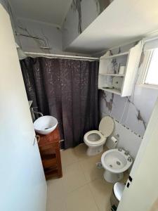 a small bathroom with two toilets and a sink at Los Altos Pergamino in Pergamino
