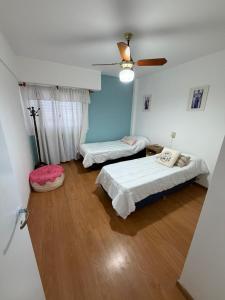 a bedroom with two beds and a ceiling fan at Los Altos Pergamino in Pergamino