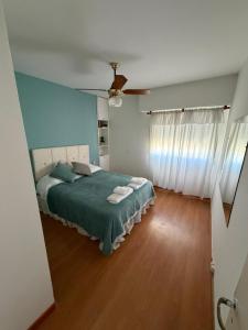 a bedroom with a bed with a green blanket at Los Altos Pergamino in Pergamino