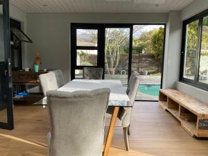 a dining room with a table and chairs and a pool at Almond Place in Tokai