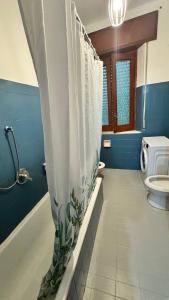 a bathroom with a shower curtain and a toilet at RaJan Home Blue in Palizzi Marina +39 photos