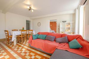 a living room with a red couch and a table at Ô pré de ma fleur in Brévonnes