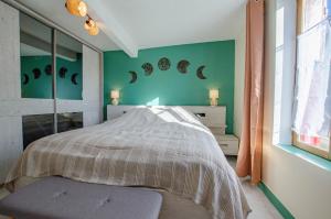 a bedroom with a bed with green walls and a window at Ô pré de ma fleur in Brévonnes