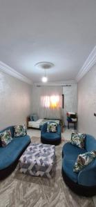 a living room with blue couches and a bed at DowntownHouse in Midelt in Midelt