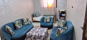 a living room with two blue couches and a bed at DowntownHouse in Midelt in Midelt
