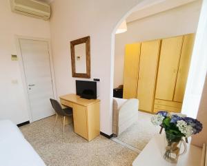 a living room with a couch and a desk with a tv at Hotel Villa Bianca in Laigueglia