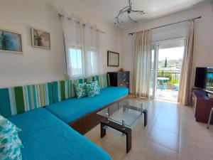 a living room with a blue couch and a television at POSEIDON SeaSide Deluxe Suites in Syvota