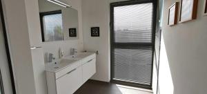 a white bathroom with a sink and a mirror at Zeebrugge Sea View, Family-Friendly & the Beach! in Zeebrugge