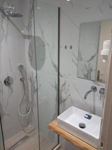 ein Badezimmer mit Dusche und Waschbecken in der Unterkunft Ηotel Della in Parga