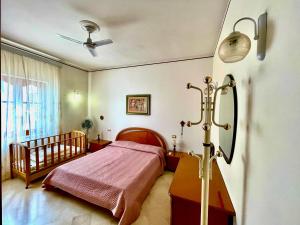 a bedroom with a bed and a ceiling fan at CasaEolia Golden in Canneto