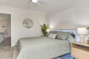 a bedroom with a bed and a table and a mirror at < 2 Mi to Coast: St Pete Beach Gem w/ Pool Access in St. Pete Beach +17 photos