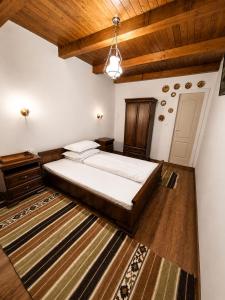 a bedroom with a bed and a wooden ceiling at Conacul Birtoc Refugiu Tradițional în Maramureș in Văleni