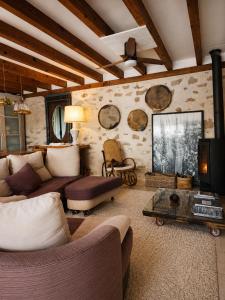 a living room with a couch and a tv at Casa rural con piscina cubierta en Segovia - Viento de Ladera in Segovia