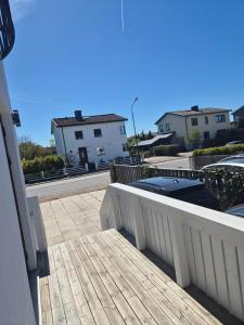 a balcony with a white fence and some buildings at Charmig bottenvåning i Limhamn in Limhamn