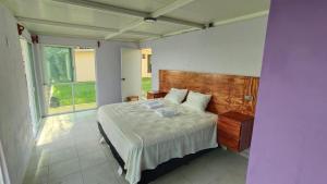 a bedroom with a bed and a large window at Villas Isla Montosa in Coyuca de Benítez