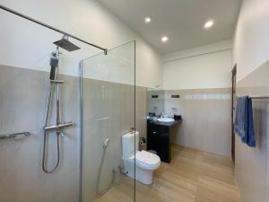 a bathroom with a shower and a toilet and a sink at Hotel Levon Ella in Ella