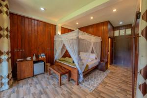 a bedroom with a bed with a canopy at Hotel Levon Ella in Ella