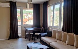 a living room with a couch and a table and windows at Belogradchik View Apartment in Belogradchik