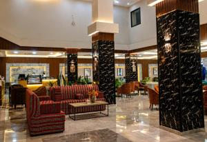 a lobby of a hotel with red chairs and a table at Delight Premium Hotel in Djibouti