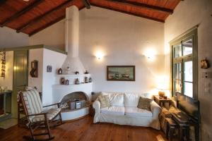 a living room with a white couch and a fireplace at Olive Cottage in Skopelos Town