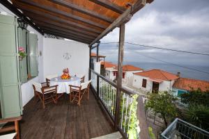 a patio with a table and chairs on a balcony at Olive Cottage in Skopelos Town