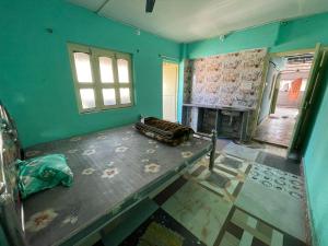 an empty room with a fireplace and a room with green walls at Narasimha Dev Guest House in mayapur