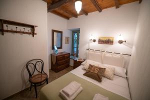 a bedroom with a bed and a table and a chair at Olive Cottage in Skopelos Town