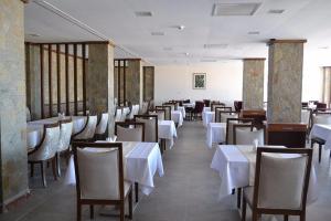a dining room with white tables and chairs at Masi Otel in Bademli