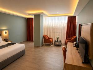 a hotel room with a bed and a table and chairs at Delight Premium Hotel in Djibouti