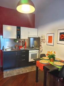 a kitchen with white cabinets and a table with plates on it at Le Petite Maison in Andria