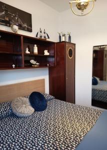 a bedroom with a bed with a blue pillow on it at Le Petite Maison in Andria