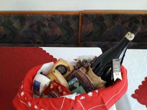 einen roten Korb mit Essen und einer Flasche Wein in der Unterkunft Haus Reason in Aurach bei Kitzbuhel