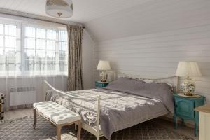 a bedroom with a bed and two tables and a chair at Lillium in Merķeļi +79 photos