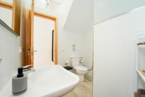 a bathroom with a white sink and a toilet at Sunny Day Deluxe 10 in Arguineguín