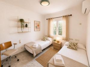 a bedroom with two beds and a desk and a chair at Villa Savanna Spacious villa with private pool near the beach in Cala en Blanes +25 photos