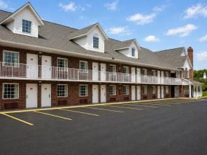a large red brick building with white doors and balconies at Carriage House Inn in Branson