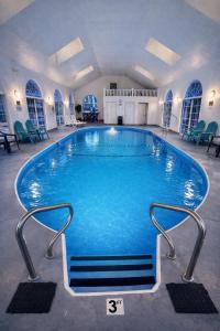 a large swimming pool with blue water in a building at Carriage House Inn in Branson
