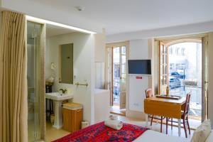 a bedroom with a bed and a desk and a sink at Casa Matriz Séc. XVI | Double or Twin w/ balcony in Penafiel