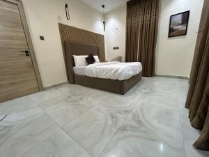 a bedroom with a bed and a large marble floor at Tombell Homes in Ibadan